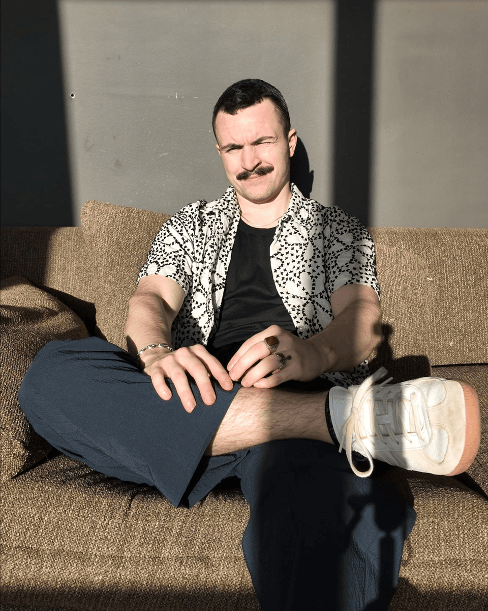 Mason, Fitr co-founder, sitting on a sofa in a patterned shirt